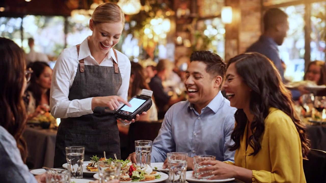 Server taking an order tableside on a handheld
