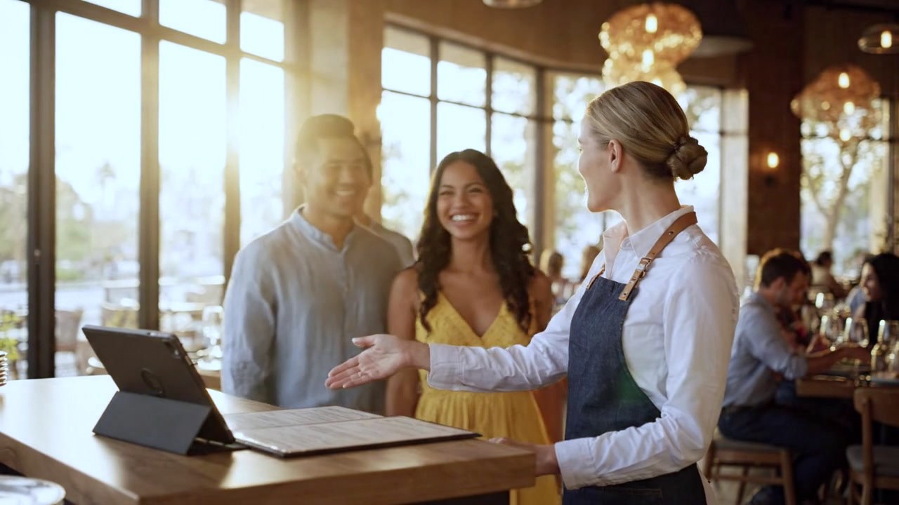 Host greeting and seating guests at the door